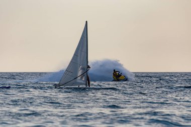 Yüzen sörfçülerle deniz manzarası ve jet ski.
