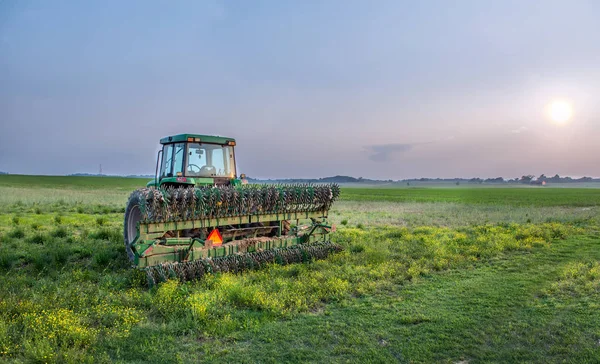 Märchenfarm mit Traktor und Pinne auf einem Feld bei Sonnenuntergang — Stockfoto