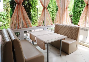 Güneşli bir günde insanlar olmadan bej mobilya yaz kafe