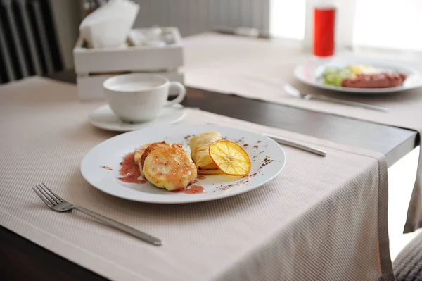 Served breakfast in the restaurant. Cottage cheese pancakes with orange ringlets with coffee