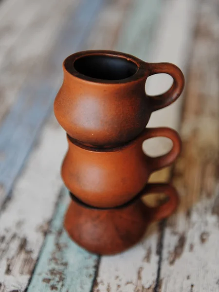 Tres tazas de cerámica de arcilla una encima de la otra. Cerámica hecha a mano. Fondo de madera —  Fotos de Stock