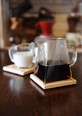 Siyah kahve cam hizmet sürahi içinde. Krem Hindistan cevizi sütü. Aygıtları el ile kahve arka planda bira için