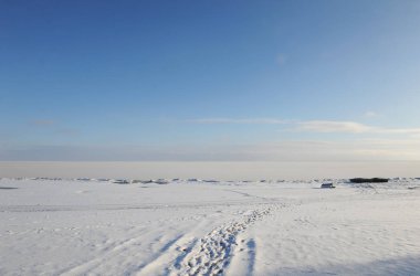 Güneşli bir kış karlı kıyı manzara. Donmuş nehir. Açık gökyüzü. Açık alan. Sahilde iki tekne