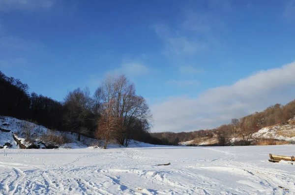 Güneşli bir kış karlı kıyı manzara. Donmuş nehir. Açık gökyüzü. Açık alan. Sahilde iki tekne