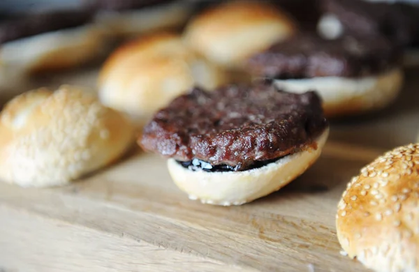 Proceso de cocción de mini hamburguesas. Cutlet en un bollo de sésamo . —  Fotos de Stock