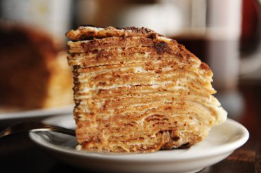 Doldurma tiramisu ve toz kakao ile krep pasta parçası plaka üzerinde servis edilir. Kahve Dükkanı iç