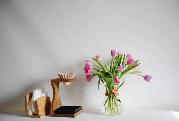 Fiori tulipani bouquet in decanter di caffè su tavolo bianco. Preparazione manuale con gocciolatore origami, filtro di carta — Foto Stock