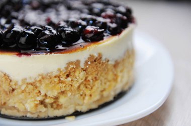 Whole blueberry cheesecake on a white plate side view