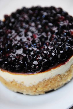 Beyaz tabak üst görünümünde yaban mersini cheesecake