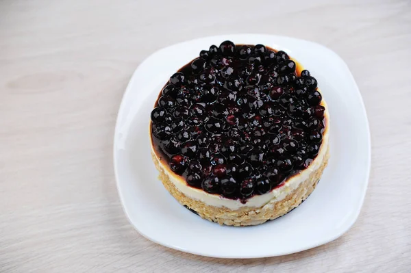 Whole blueberry cheesecake on a white plate — Stock Photo, Image