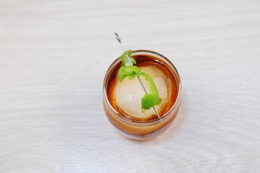 Limonlu kokteyl rom kola ve bütün yuvarlak buz parçası. Açık ahşap yüzeyde. Üst görünüm, tasarım için boş alan