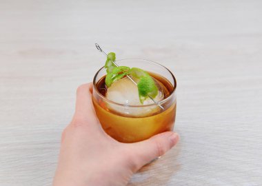 Limonlu kokteyl viski rom kola ve yuvarlak bir parça buz. Açık ahşap bir yüzey üzerinde elde