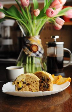 Beyaz tabakta şekerlenmiş meyve ve lezzet ile Muffins kek. Fransız basın kahvesi. Dekantörde pembe laleler