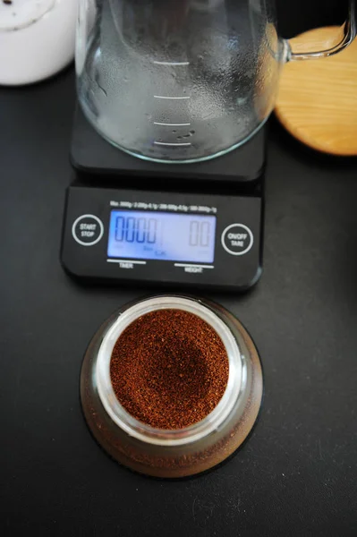 Свежий молотый кофе в ручной кофемолке контейнер вид сверху. Электронные весы с таймером — стоковое фото