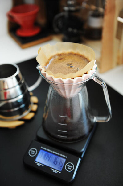 Фильтрующий черный кофе заваривают розовой капельницей. Электронная шкала таймера. Концепция специализации
