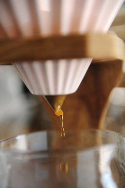 Kahve damlatma kapatın. Ahşap stand üzerinde pembe seramik origami damlatıcı alternatif bira.