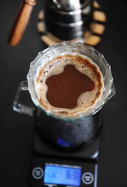 Alternative Kaffeezubereitung. Klarglas über Tropfer v60 mit Papierfilter gießen. elektronische Waage. Ansicht von oben — Stockfoto