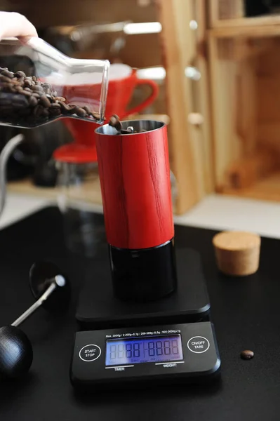 带定时器的电子秤上的红色手动咖啡研磨机。替代酿造和特殊概念 — 图库照片