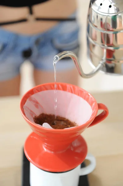 Menina barista fabrica método de gotejamento de café. Despejar água da chaleira gooseneck em funil vermelho hario v60 . — Fotografia de Stock
