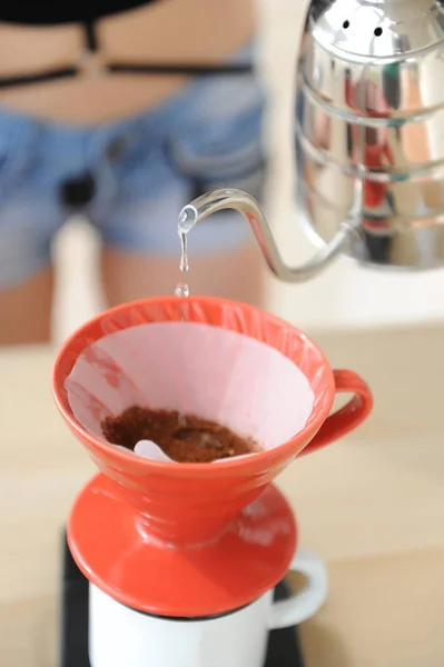Menina barista fabrica método de gotejamento de café. Despejar água da chaleira gooseneck em funil vermelho hario v60 . — Fotografia de Stock
