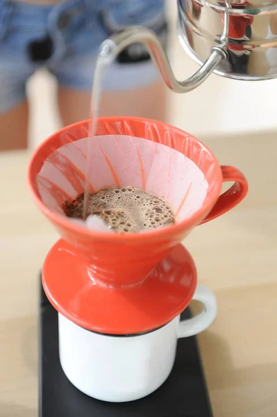 Menina barista fabrica método de gotejamento de café. Despejar água da chaleira gooseneck em funil vermelho hario v60 . — Fotografia de Stock