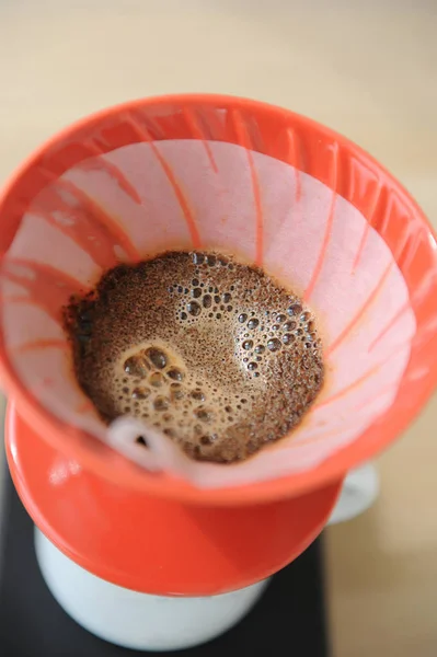 Frischer Kaffee blüht in rotem Hario v60-Trichter. — Stockfoto