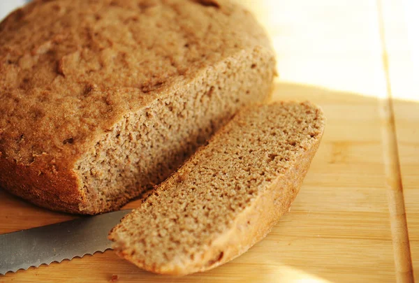 Pan integral de centeno y trigo casero recién horneado. Rebanada de pan en rodajas en el tablero —  Fotos de Stock