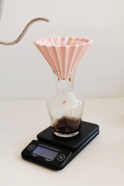 Elektronik ölçekte origami damlatıcısı ile demlenen kahve