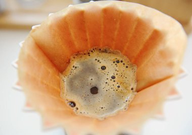 Coffee blooming closeup. Manual brewing in origami dripper clipart