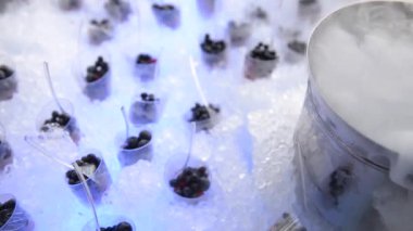 Berry tatlı buz üzerinde. Meyveleri tatlı çatal ile sis ile cam bardak sıvı azot içinde