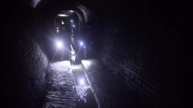 Kiev, Ukrayna 08 Ocak 2018: el feneri evli ve iki çocuk yeraltı nehri Klov tur sırasında yeraltı tüneli için Atıksu boyunca yürümek.