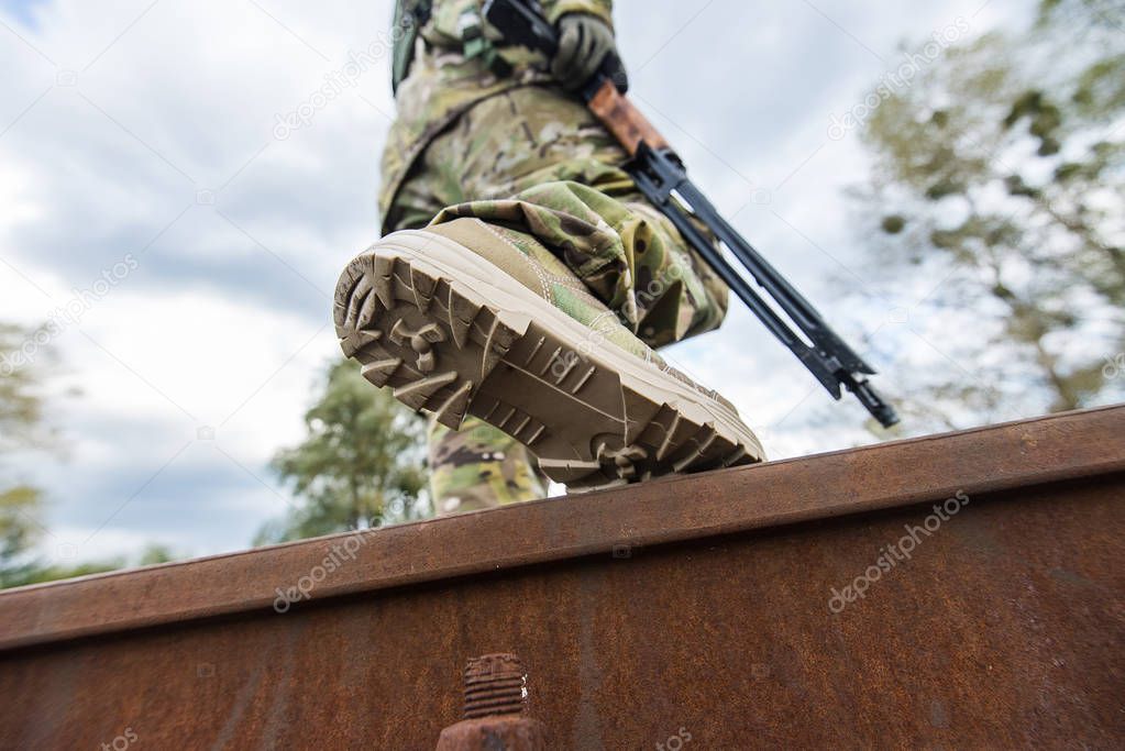 Soldier in uniform with a rifle in his hands.Low angle.Selective focus