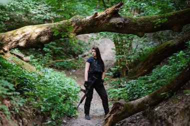 Kızıl saçlı kız ormandaki tüfekle. Seçici odak