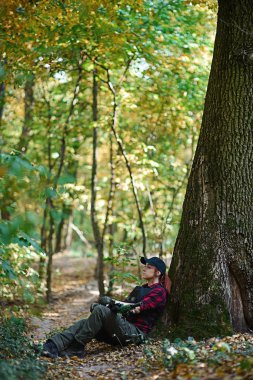 Renkli saçlı Genç kız ormanda oturur