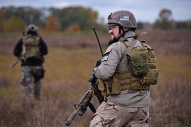 Kiev, Ukrayna 14 Ekim 2017: kurşun geçirmez ceket, kask, adam onun silahla görünüyor uzakta airsoft sırasında askeri simülasyon oyunu Kiev, Ukrayna Ekim eller 14,2017.