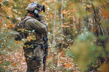 Kiev, Ukrayna 14 Ekim 2017: tüfek airsoft askeri simülasyon sırasında cep telefonu üzerinde Kiev, Ukrayna Ekim ayında oyun konuşurken ile askeri üniformalı adam 14,2017.