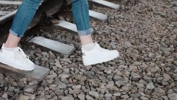 Slanke dames benen zijn moedig het oversteken van de spoorweg — Stockvideo