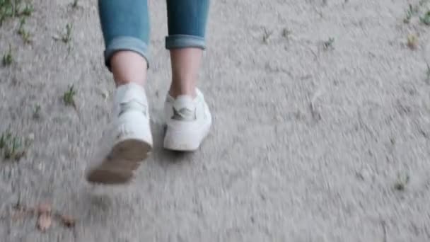 Vista posterior de la chica, que está caminando y corriendo de repente — Vídeos de Stock