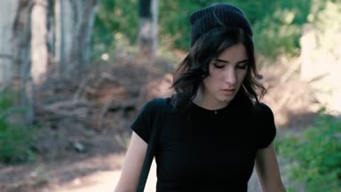 Genç bir kadın dikkatli yürüyüş ve korku ile etrafa