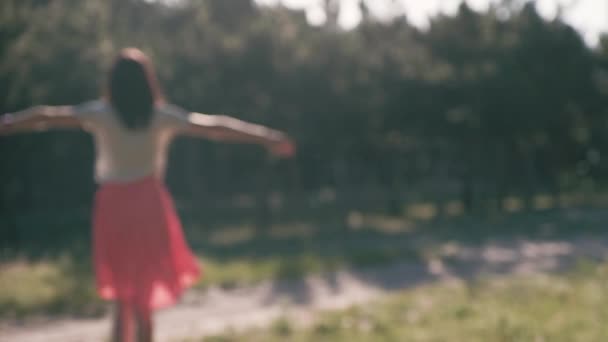 An unfocused silhouette of a young beautiful woman, who puts her hands behind her head — Stock Video