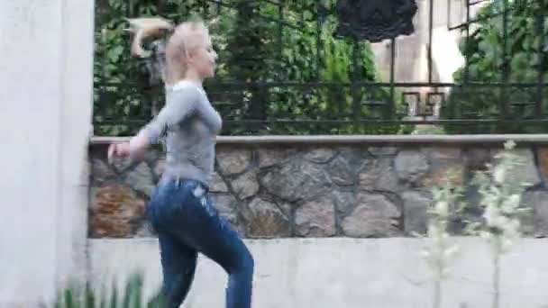 A young woman runs and hops joyfully along the hedge — Stock Video