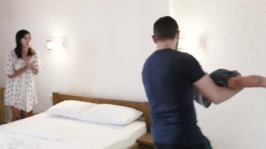 Ebeveynler çocuklarının bir otel odasında oynamak. Baba ve oğlu onun elinde tutan spin sonra onu dikkatli bir şekilde yatağa koyar. Bu arada anne heyecan verici ellerini gürlemesi