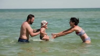 Mutlu anne çocuklarının Denizi ile oynamak. Baba iplik, oğlu onun el ve annesi onu yakalamaya çalışıyor holding
