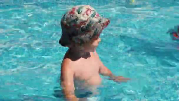 Un bambino felice batte le mani mentre cammina in piscina — Video Stock