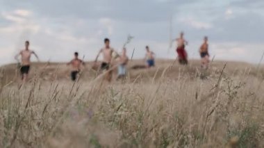 Çocuklar, sarı çim ile bir alanda çalışan rekabet bir görünümünü