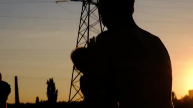 Genç Erkek, bir eğitim gün batımına karşı koşu siluetleri