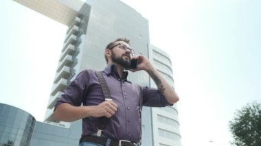 Ciddi görünümlü bir adam bir telefonla konuşuyor