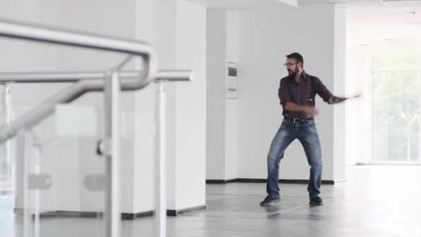 Un hombre aparece en un pasillo y empieza a bailar tonto. — Vídeos de Stock