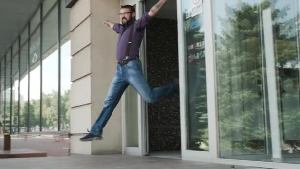 Un hombre salta de la entrada del edificio y comienza a bailar tonto . — Vídeos de Stock