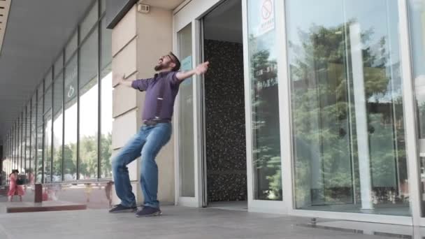 Un hombre salta de la entrada del edificio y comienza a bailar tonto . — Vídeo de stock